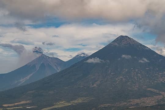 From left to right, Fuego (erupting), Acatenango (hiding in the back) and Agua up front.
