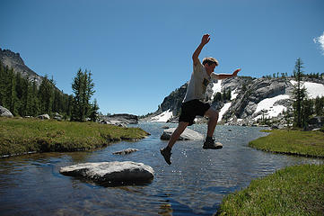 Kody takes a leap from a small rock to the edge of Perfection Lake