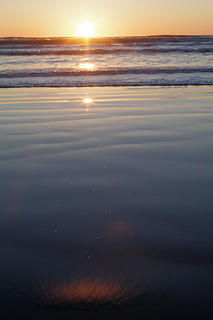 Setting sun, sunglint on water, sunglint on sand