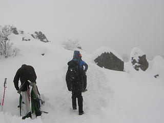 Hikers onward and upward to the snow covered rocky section.