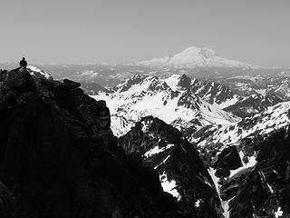 A climber surveys the terrain from the summit of Eightmile looking south towards Mount Rainier.