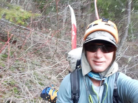 Challenging bushwhacking with skis and boots sticking out