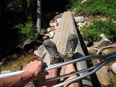 butt scootin' with the crutches across the log bridge