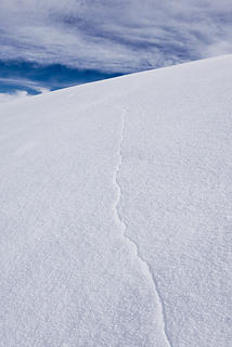 One of the long cracks in the thin icy crust. On a glacier this would be concerning, showing the possible presence of a crevasse.