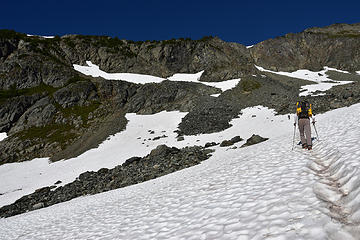 Snow patch south of Yang Yang Lakes.   Boot path climbs up to high snow patches where it traverses left on steep heather/rock rib to gain the skyline in upper LH corner of image.
