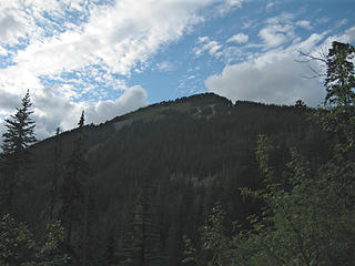 Defiance summit from the talus field just below Mason Lake. The trail begins traversing the summit near the notch in the trees just below and to the right of the summit