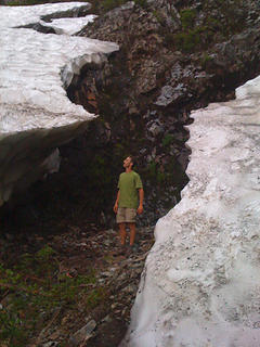 Me between remnants of a massive snow bank at a gully crossing around 3750 ft