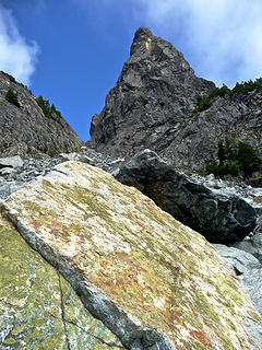 Gunn Peak's summit block towers above rocks in the talus field