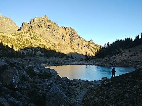 Eric and a frozen tarn with Mt. Clark beyond