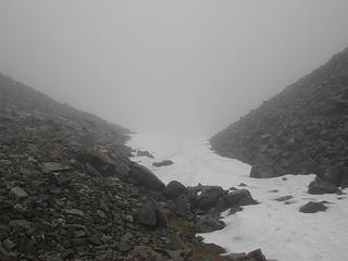 Near the pass looking back at the snowfield drop-off to the ice-covered tarn