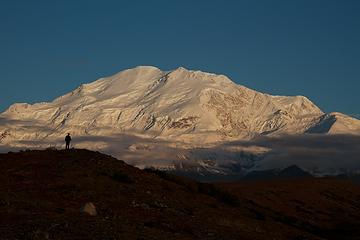 A hiker silhouetted against Mount Mckinley.