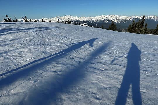 Shadows hiking along the wide crest