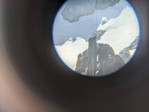 Sighting the SW summit of Enchantment peak from the NE summit with the theodolite, June 2023